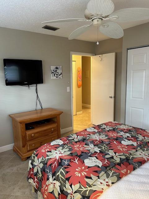 bedroom featuring ceiling fan and a textured ceiling