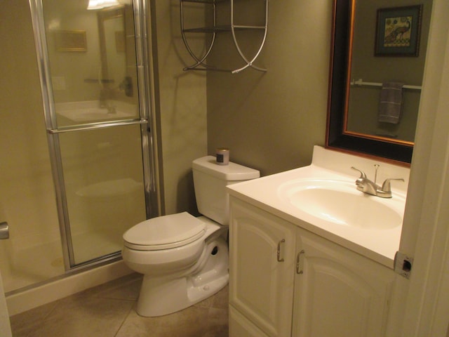 bathroom with tile patterned floors, toilet, a shower with door, and vanity