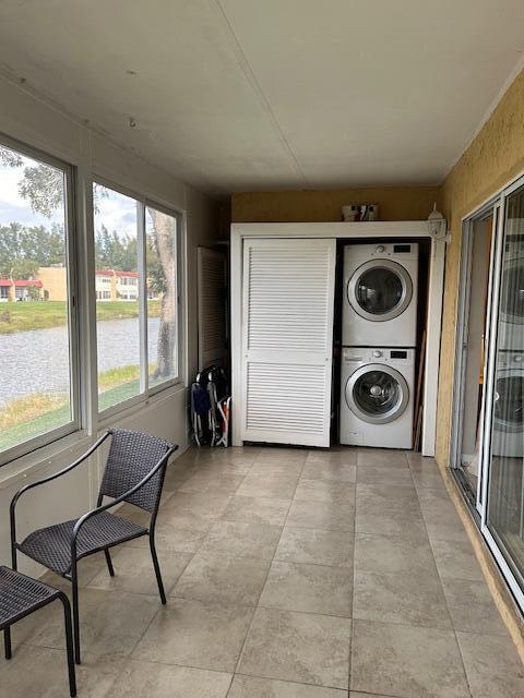 clothes washing area with stacked washing maching and dryer