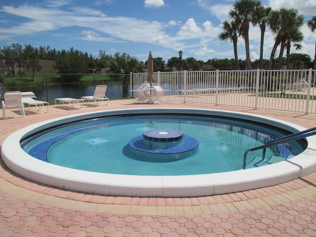 view of pool with a water view and a patio area