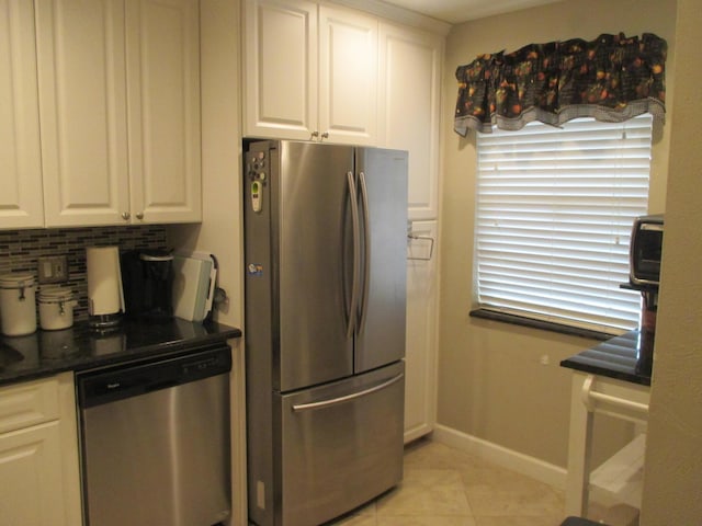 kitchen with appliances with stainless steel finishes, light tile patterned floors, decorative backsplash, and white cabinets