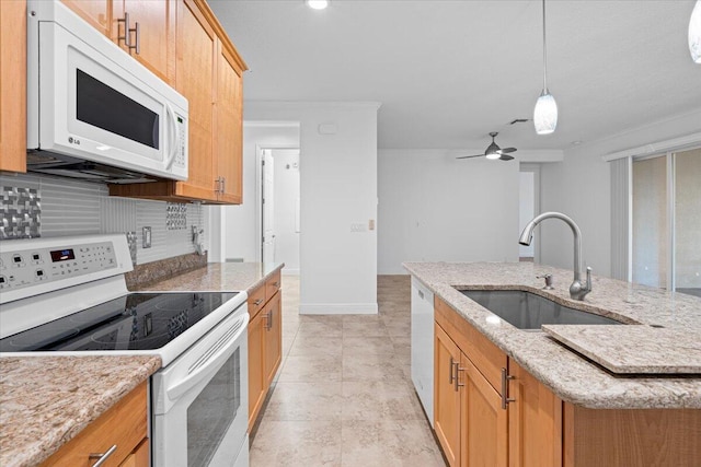 kitchen featuring ceiling fan, sink, backsplash, white appliances, and a center island with sink