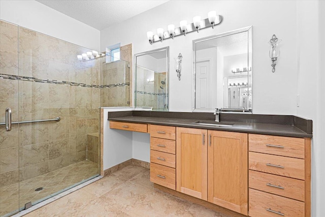 bathroom with a textured ceiling, vanity, and walk in shower