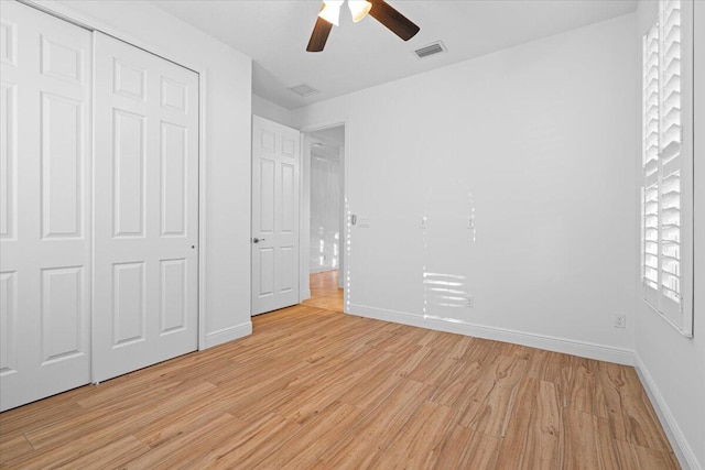 unfurnished bedroom featuring ceiling fan, light wood-type flooring, and a closet