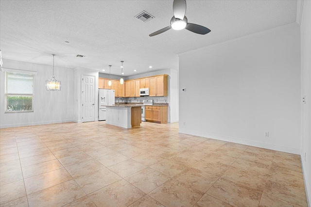 9716 SW Chestwood Ave, Port Saint Lucie, FL 34987 - kitchen with crown molding, ceiling fan with notable chandelier, white appliances, visible vents, and open floor plan