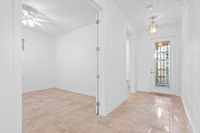 foyer with ceiling fan, a textured ceiling, and ornamental molding