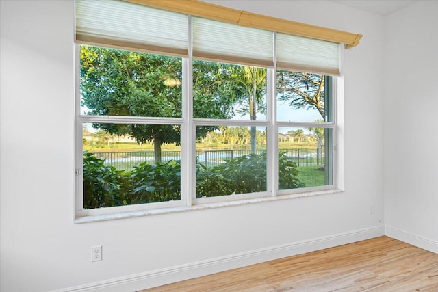 9716 SW Chestwood Ave, Port Saint Lucie, FL 34987 - empty room featuring a water view, baseboards, and wood finished floors