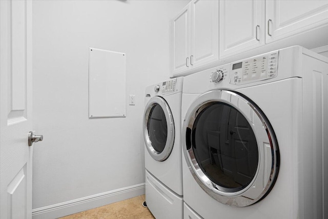 washroom with washer and clothes dryer, light tile patterned flooring, and cabinets