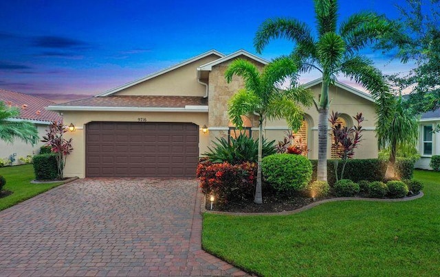 view of front of property featuring a lawn and a garage