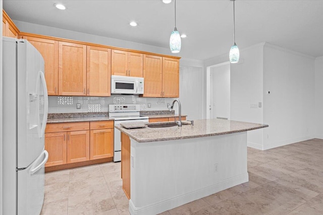 kitchen featuring sink, light stone counters, an island with sink, pendant lighting, and white appliances