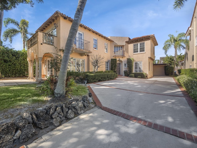 mediterranean / spanish house featuring a garage and a balcony