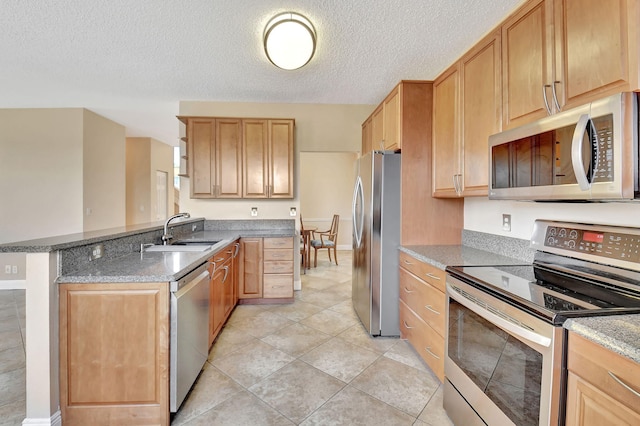 kitchen featuring sink, stainless steel appliances, kitchen peninsula, a textured ceiling, and light tile patterned floors