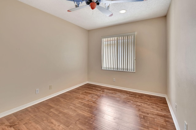 spare room featuring ceiling fan, wood-type flooring, and a textured ceiling