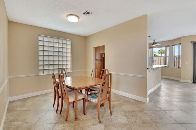 dining room with ceiling fan and a textured ceiling