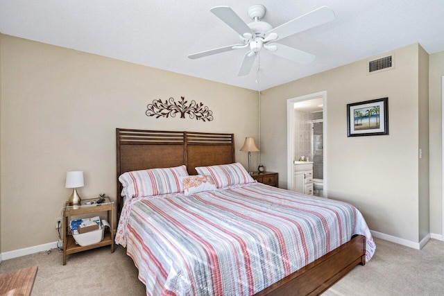 bedroom with light carpet, ensuite bath, and ceiling fan