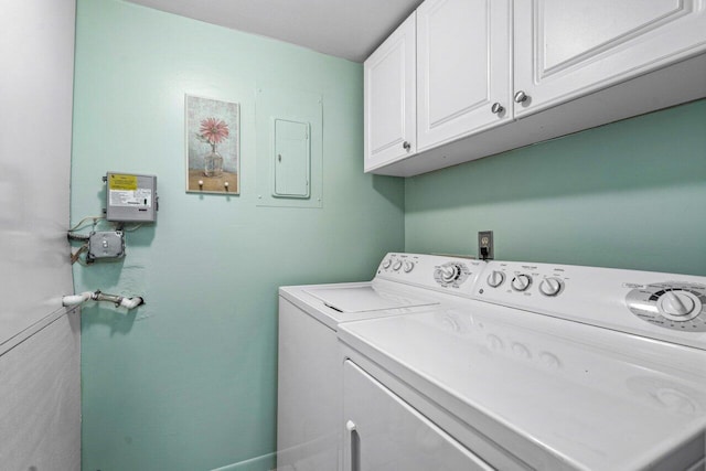 clothes washing area featuring cabinets and washer and dryer