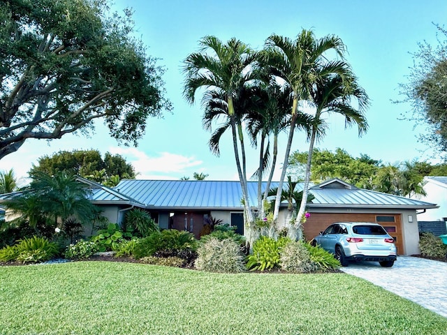 ranch-style house with a garage and a front lawn