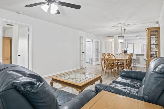 living room featuring ceiling fan and light hardwood / wood-style flooring