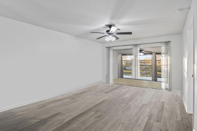 empty room with a textured ceiling, ceiling fan, and wood-type flooring