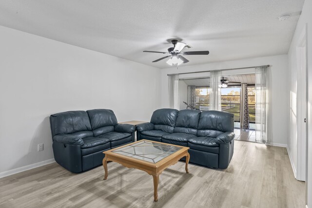 living room featuring a textured ceiling, ceiling fan, and light hardwood / wood-style flooring