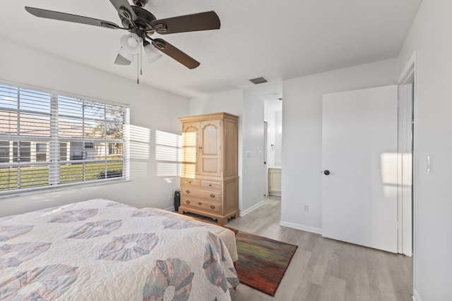 bedroom with ensuite bath, light wood-type flooring, and ceiling fan