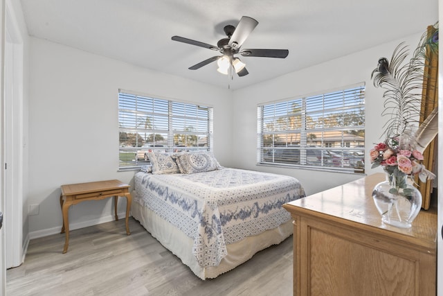 bedroom featuring multiple windows, ceiling fan, and light wood-type flooring