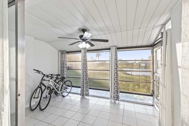 sunroom featuring ceiling fan, plenty of natural light, and a water view