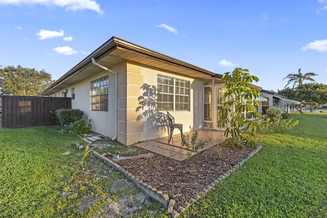 view of home's exterior with a yard and a patio area