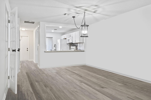 interior space with an inviting chandelier, wood-type flooring, and sink