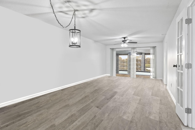 interior space with hardwood / wood-style floors and ceiling fan with notable chandelier