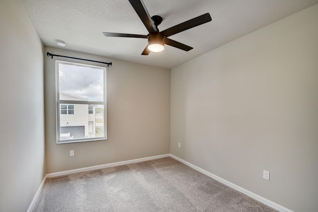 carpeted spare room featuring ceiling fan and a textured ceiling