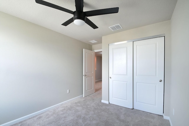 unfurnished bedroom with ceiling fan, light colored carpet, and a closet