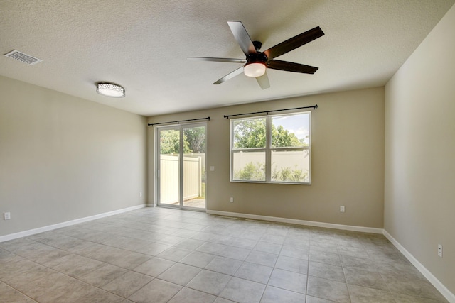 tiled spare room with ceiling fan and a textured ceiling