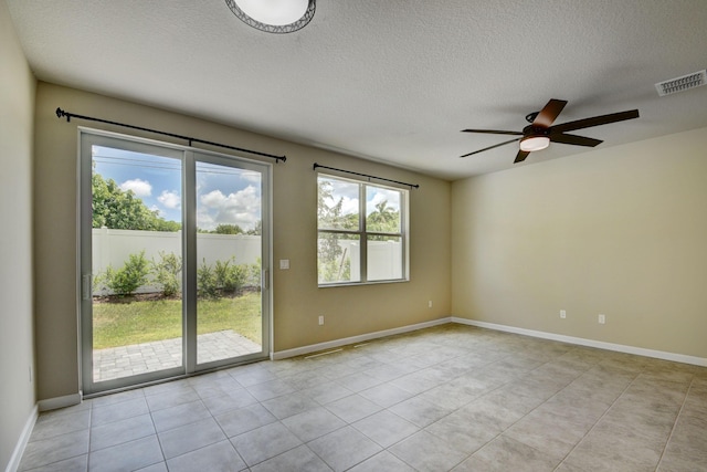 tiled spare room featuring ceiling fan and a textured ceiling