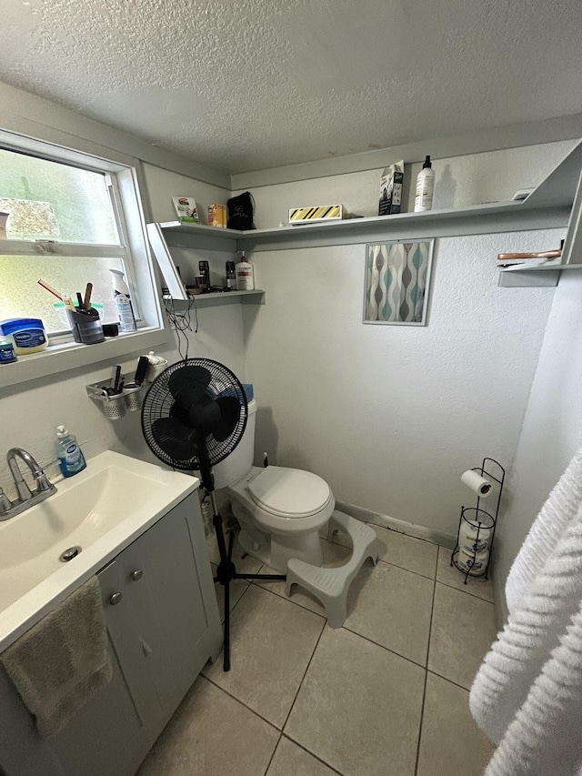 bathroom featuring tile patterned floors, toilet, vanity, and a textured ceiling