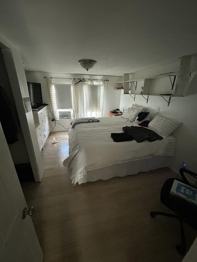 bedroom with cooling unit and light hardwood / wood-style flooring