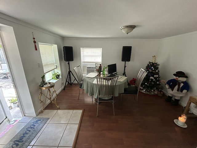 dining area with hardwood / wood-style flooring, cooling unit, and crown molding