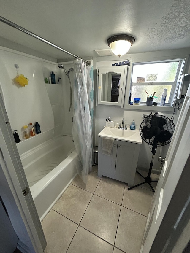 bathroom featuring a textured ceiling, vanity, shower / bath combo, and tile patterned flooring