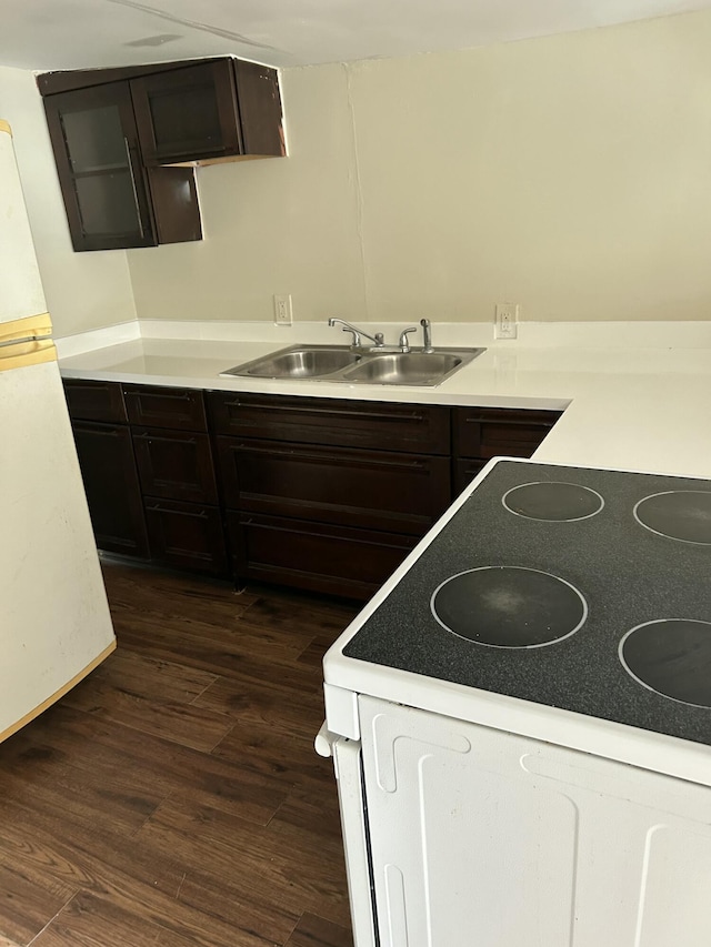 kitchen featuring dark wood-type flooring, sink, white range with electric stovetop, and dark brown cabinets