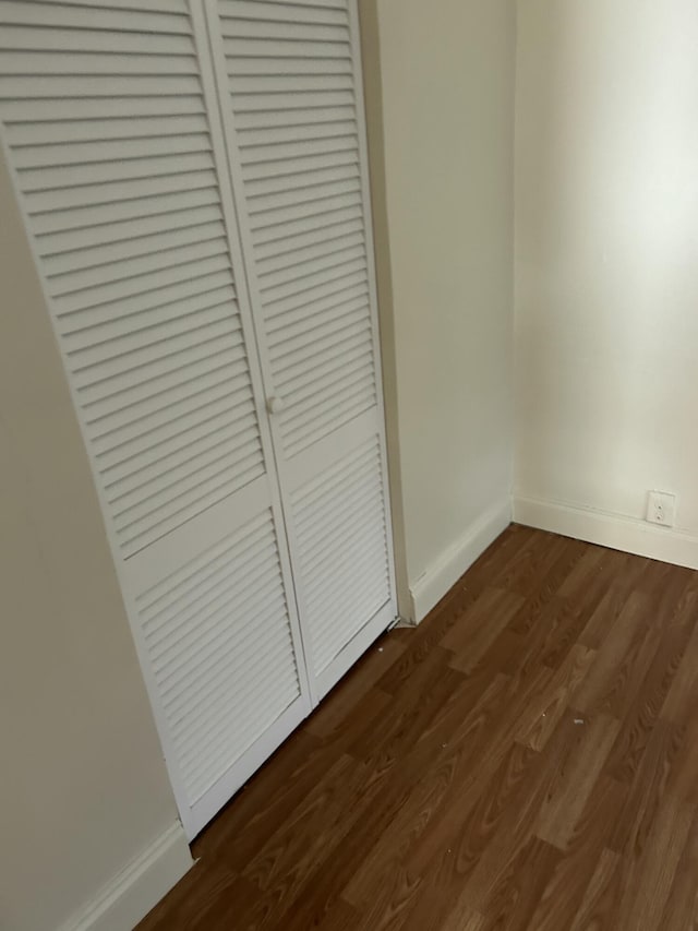 unfurnished bedroom featuring a closet and dark hardwood / wood-style floors