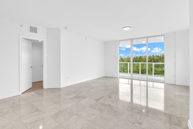 unfurnished room with expansive windows