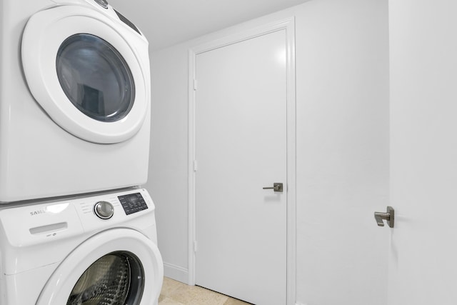 laundry room with stacked washing maching and dryer and light tile patterned floors