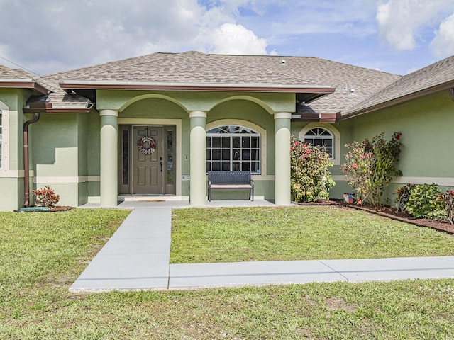 view of exterior entry with a lawn