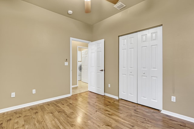 unfurnished bedroom featuring ceiling fan, washer / clothes dryer, a closet, and light hardwood / wood-style flooring