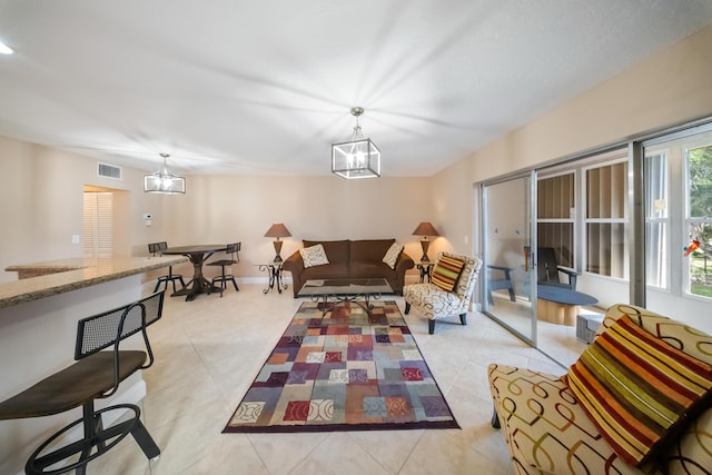 tiled living room featuring a notable chandelier