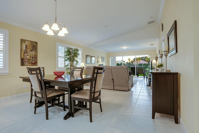 dining area with a chandelier, ornamental molding, lofted ceiling, and light tile patterned flooring