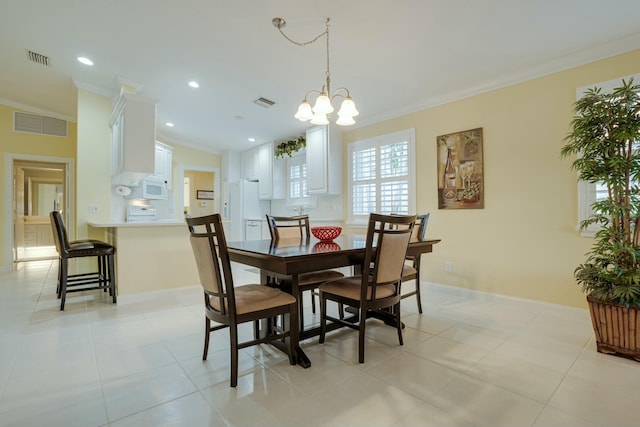 dining space with an inviting chandelier, light tile patterned flooring, and ornamental molding