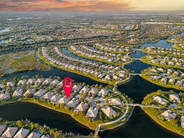 aerial view at dusk featuring a water view