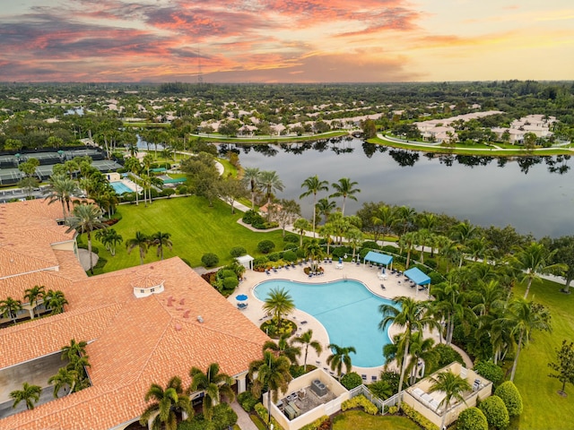 aerial view at dusk featuring a water view