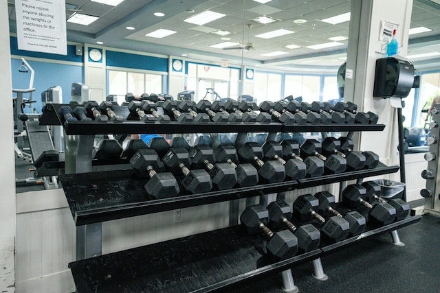 exercise room featuring a drop ceiling and ceiling fan